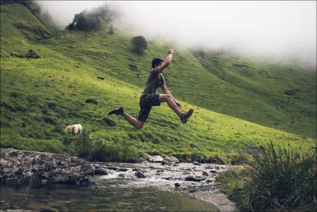 inspirational picture of a boy jumping over a creek