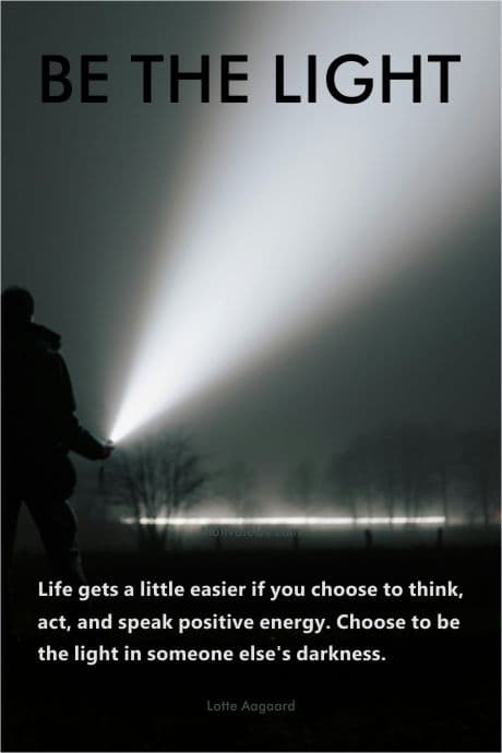 person in the dark shining a bright light into the sky
