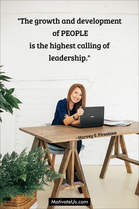 woman at wooden desk with a quote by Harvey S. Firestone